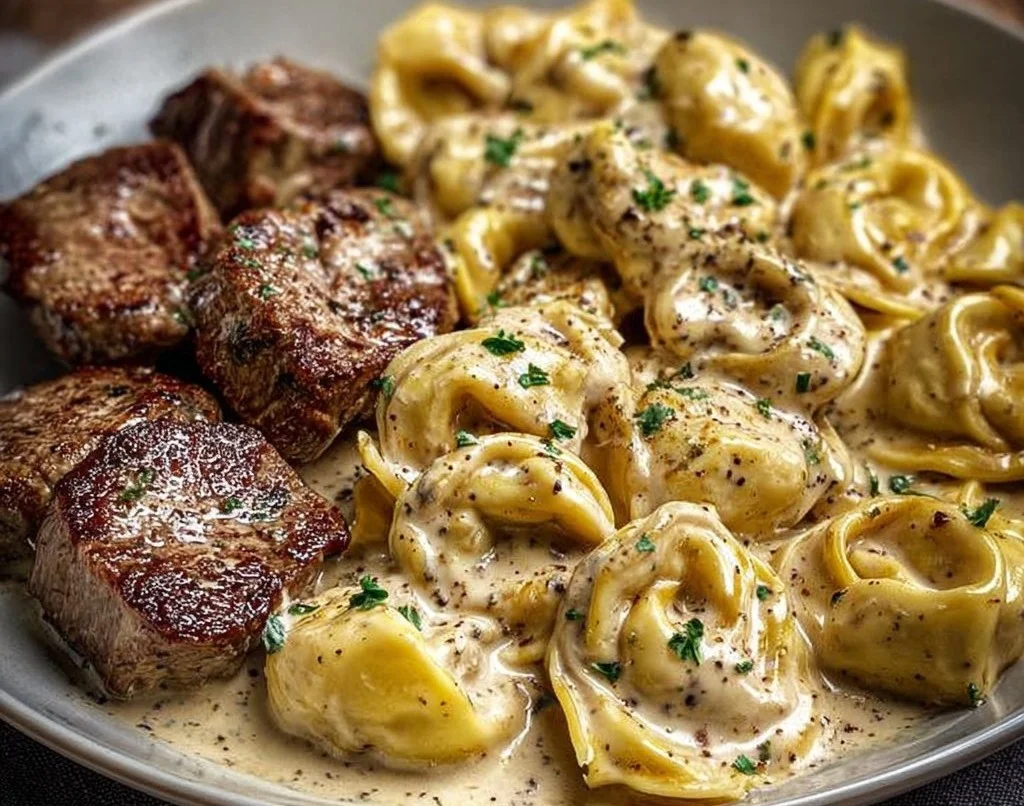 Plat de tortellini au steak dans une sauce crémeuse avec ail écrasé.